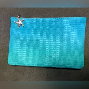 Blue makeup bag with seashell charm on zipper
